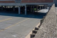 cars parked on the side of the road at a large garage area next to a highway