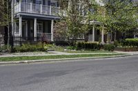 two men on motorcycles passing by a building in a residential neighborhood in springtime and sunny day