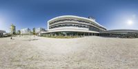 a panoramic view of the outside of a large office building on a beach