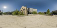 360 - angle photograph of an outdoor courtyard with a church and a street in the background