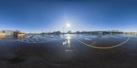 a parking lot with a sun shining over it with a blue sky background and yellow painted lines that look like smiley faces