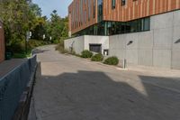 a concrete walkway between two buildings on the side of the road, and a stop sign