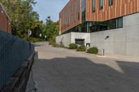 a concrete walkway between two buildings on the side of the road, and a stop sign