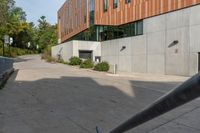 a concrete walkway between two buildings on the side of the road, and a stop sign