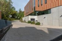 a concrete walkway between two buildings on the side of the road, and a stop sign