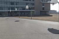 a man is playing basketball on his skateboard in the sun outside of a building