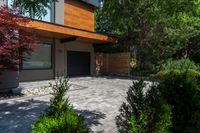 a home with a patio, large trees and shrubs around a small gated area