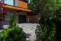 a home with a patio, large trees and shrubs around a small gated area