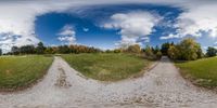 a photo taken from the inside of a fish eye lens showing two roads in front of trees