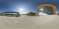 a skate park with ramps, some skateboards and people on the ground around it