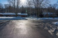 a house and trees are seen in the snow on this street intersection, in front of a wintery scene