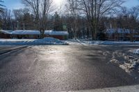 a house and trees are seen in the snow on this street intersection, in front of a wintery scene