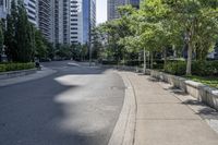 a car driving down an empty street lined with tall buildings and trees in the background