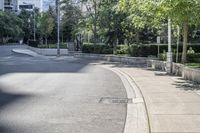 a car driving down an empty street lined with tall buildings and trees in the background