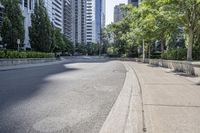 a car driving down an empty street lined with tall buildings and trees in the background