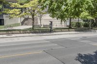 a street view with parking meters and trees in front of the building by the road