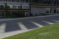 a person on a cell phone walking down the sidewalk outside a tall building with a sign for the business