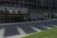 a person on a cell phone walking down the sidewalk outside a tall building with a sign for the business