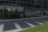 a person on a cell phone walking down the sidewalk outside a tall building with a sign for the business