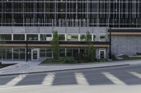 a parking meter at an office building with large windows and lots of light in the windows