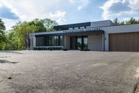 a building has a garage and sidewalk in front of it to the side, a large car sits parked on the side