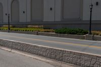 a man riding a skateboard on the side of a road next to a wall