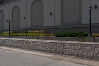 a man riding a skateboard on the side of a road next to a wall