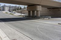 a street underpass with cars driving under it and buildings behind it with an overpass