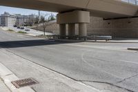 a street underpass with cars driving under it and buildings behind it with an overpass