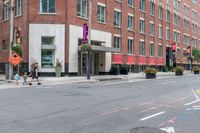 the sidewalk is painted red and blue while people walk by on the sidewalk near a building