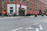 the sidewalk is painted red and blue while people walk by on the sidewalk near a building