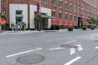 the sidewalk is painted red and blue while people walk by on the sidewalk near a building