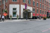 the sidewalk is painted red and blue while people walk by on the sidewalk near a building