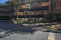 an intersection with a red brick building and blue sky above and over it there is a street next to the road with trees