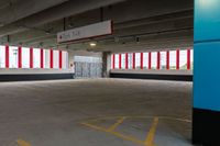 an empty parking garage with red and white striped windows over concrete floors and floor tiles