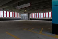 an empty parking garage with red and white striped windows over concrete floors and floor tiles