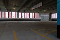 an empty parking garage with red and white striped windows over concrete floors and floor tiles