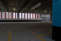 an empty parking garage with red and white striped windows over concrete floors and floor tiles