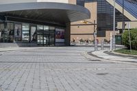 a person sitting at the bench in front of a mall that is empty of people