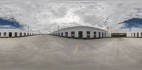 a fish eye lens reflecting a warehouse in a parking lot filled with lots of buildings