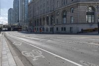 a bus traveling down the street next to tall buildings in the city with a bicycle lane