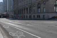 a bus traveling down the street next to tall buildings in the city with a bicycle lane