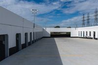 an industrial parking garage with two vans parked next to the building area and overhead utility poles