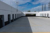 an industrial parking garage with two vans parked next to the building area and overhead utility poles