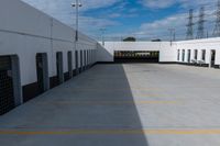 an industrial parking garage with two vans parked next to the building area and overhead utility poles