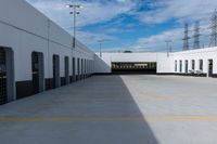 an industrial parking garage with two vans parked next to the building area and overhead utility poles