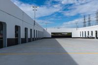 an industrial parking garage with two vans parked next to the building area and overhead utility poles