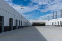 an industrial parking garage with two vans parked next to the building area and overhead utility poles