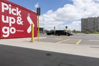 an image of a parking lot with cars parked in it and the signs advertising the place