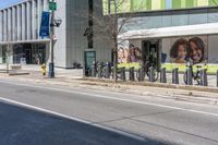 a city street has many bicycles chained to it and stores and businesses on the sides